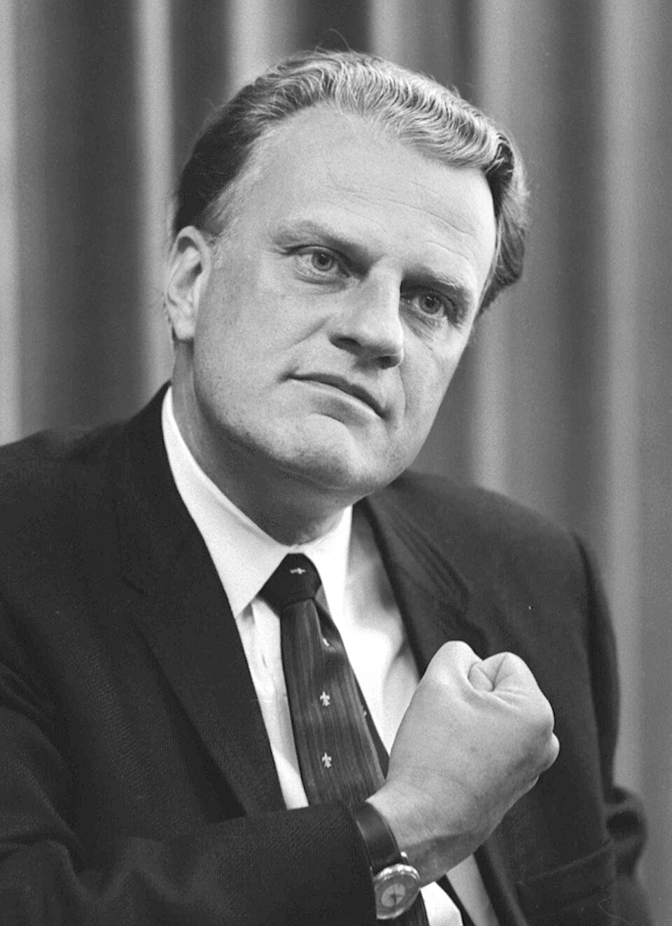 Billy Graham in a black-and-white portrait, wearing a suit and tie